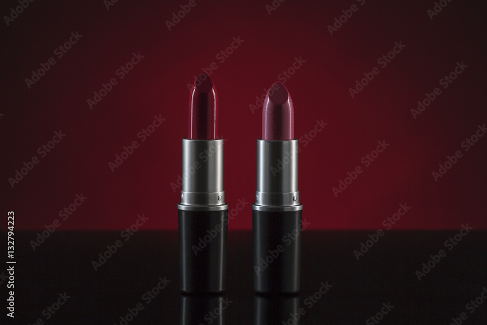 Red and pink lipstick with clipping path standing against dark background Red and pink lipstick with clipping path standing against dark background