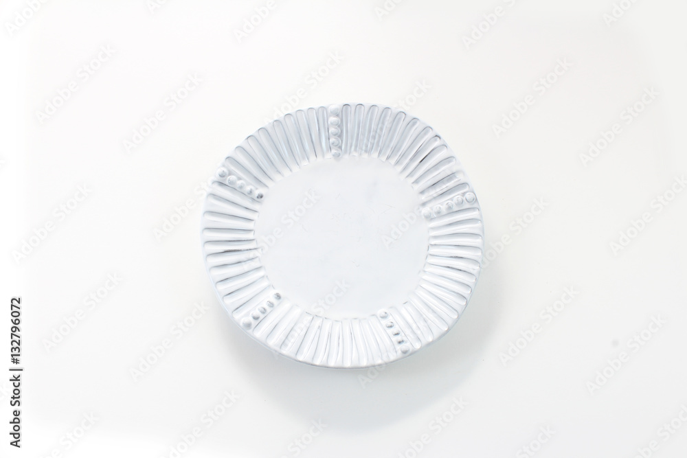 Hand made white porcelain plate with fluted rim, isolated on white
