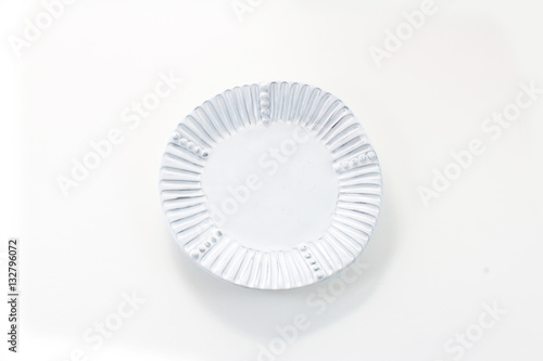 Hand made white porcelain plate with fluted rim, isolated on white 