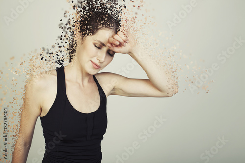 Fotomural young woman  tired on bg disintegrate into particles effects