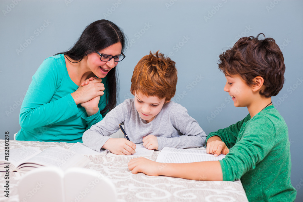 Mother is teaching her sons at home. 