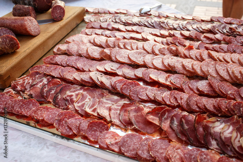 Sliced salted meat lies on large mirror tray