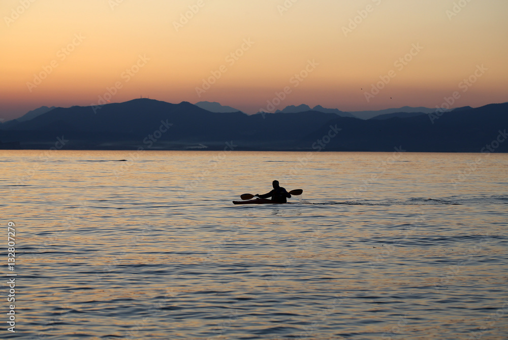 Lonely paddler on the lake during the sunset Lonely paddler on the lake during the sunset