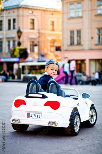 What's up? Charming boy drives little white BMW's cabrio © IVASHstudio