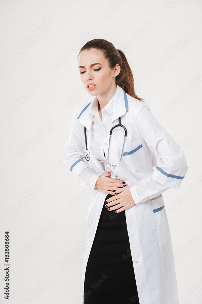 Unhappy upset young woman doctor having stomach ache Unhappy upset young woman doctor having stomach ache