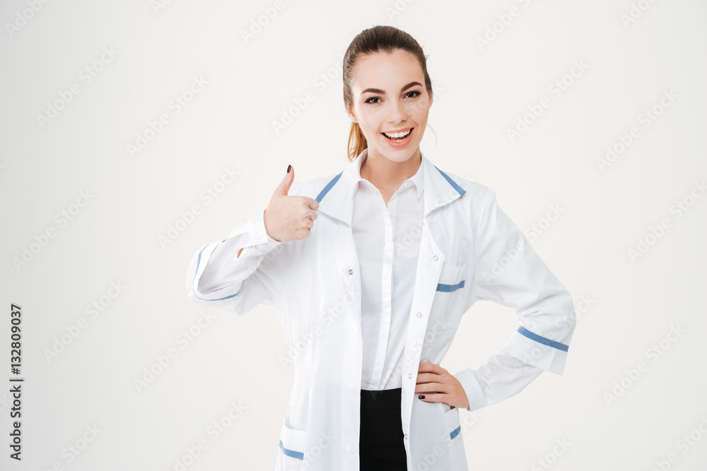 Happy charming young woman doctor showing thumbs up Happy charming young woman doctor showing thumbs up