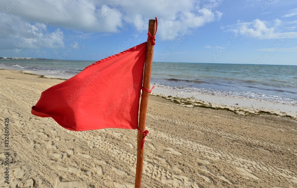 A red warning flag on the beach in the Caribbean A red warning flag on the beach in the Caribbean