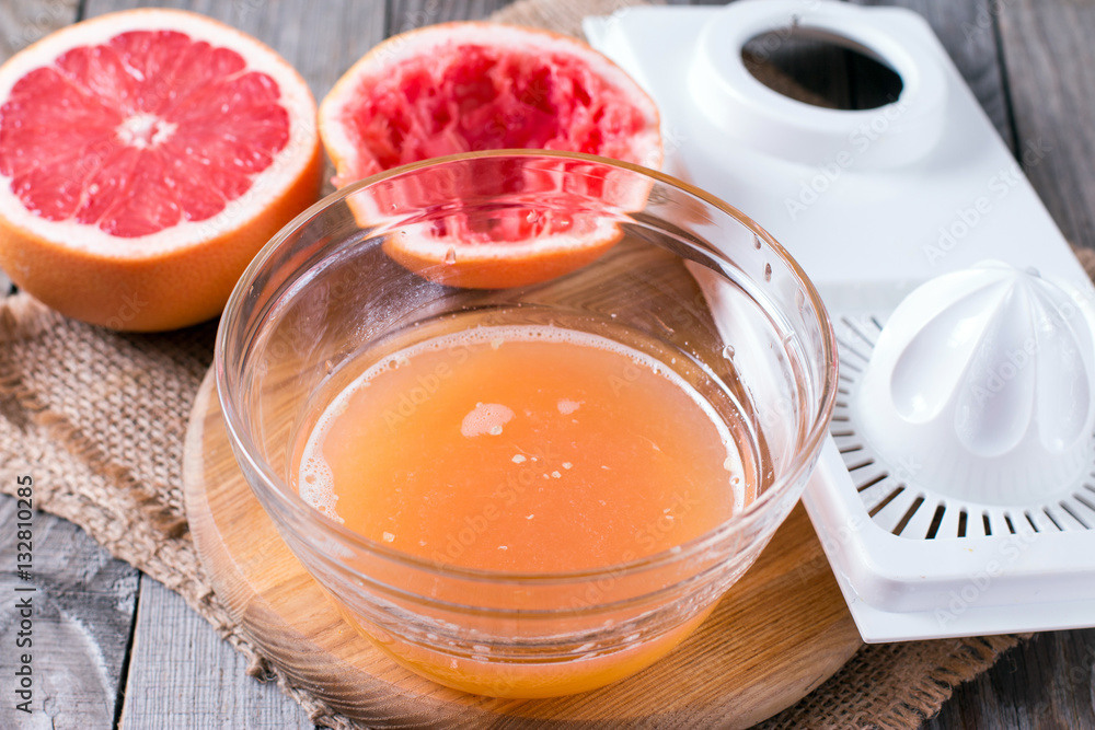squeezing juice from an orange on a manual squeezer squeezing juice from an orange on a manual squeezer