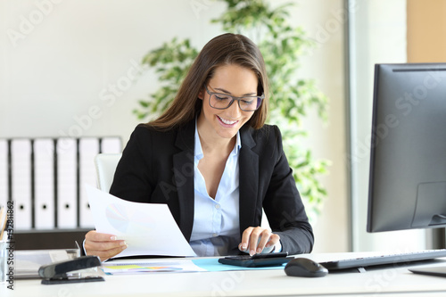 Businesswoman using a calculator at office photo