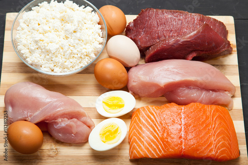 Proteins, fish, cheese, eggs, meat and chicken on a black background