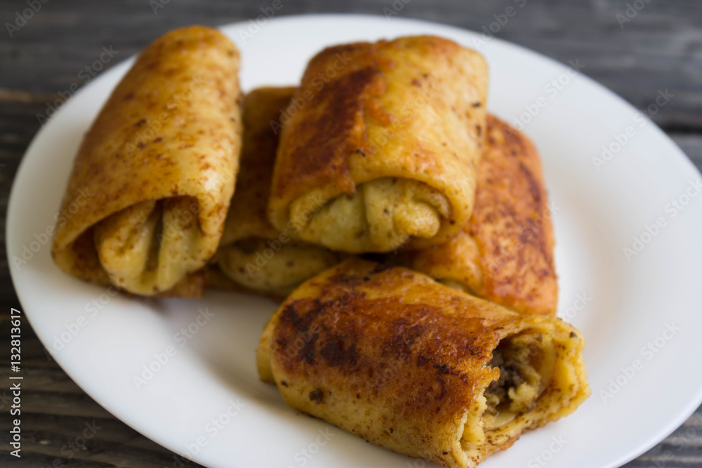 Fried pancakes with meat on a white plate Fried pancakes with meat on a white plate