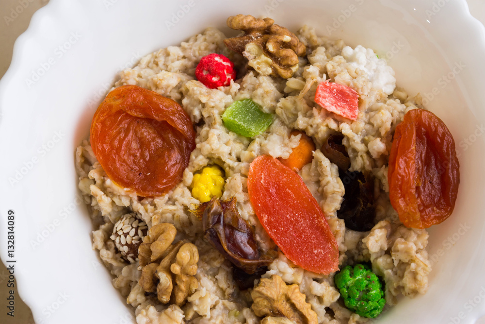 Fototapeta premium Oatmeal with dried fruit and nuts. Dietary food.