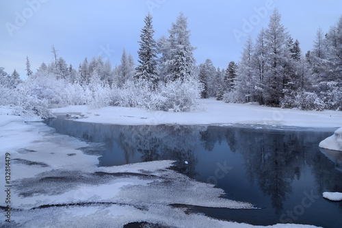 Winter landscape with stream and reflections