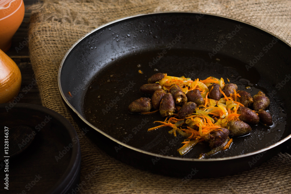 Fried chicken hearts with vegetables on a frying pan Fried chicken hearts with vegetables on a frying pan