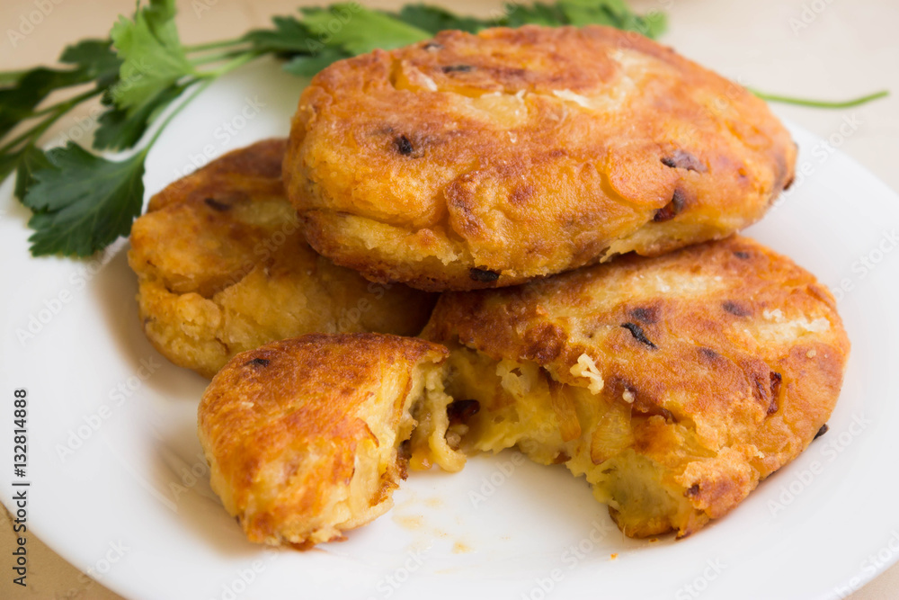 Potato patties with fried onions on a white plate Potato patties with fried onions on a white plate