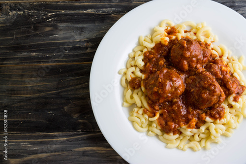 Meatballs in tomato sauce with pasta on a white plate