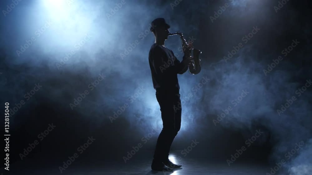 Slow motive on the saxophone. Musician in a smoky studio Slow motive on the saxophone. Musician in a smoky studio