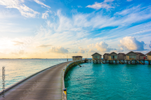 Beautiful sunrise with water villas in tropical Maldives islan
