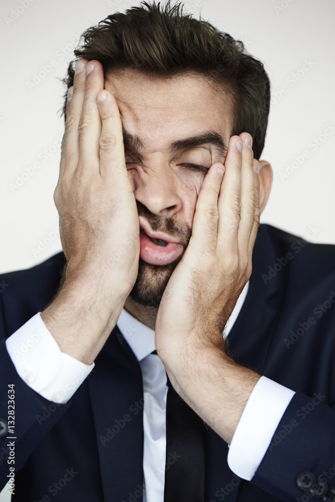 Businessman pulling face in boredom, studio Businessman pulling face in boredom, studio