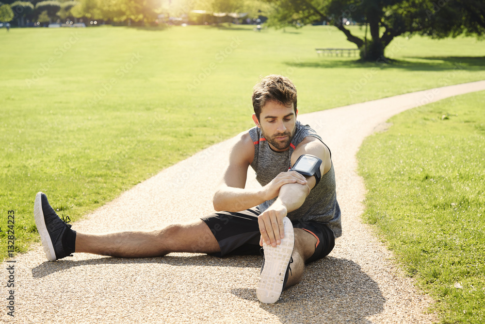 Athlete stretching in park on path