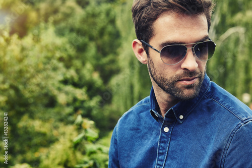 Guy in blue denim and shades, looking away