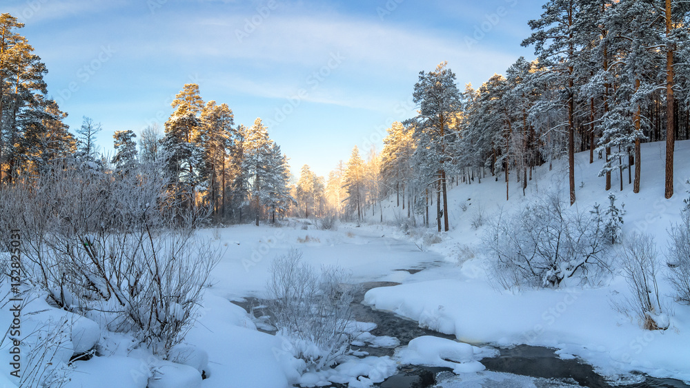морозный солнечный день в уральском лесу с замерзшей рекой, Россия, январь