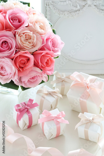 Bouquet of beautiful pink roses with gifts on the table,Romantic style