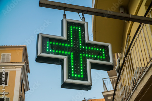 the cross - the sign of the pharmacy hanging on the streets of European cities