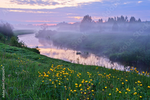  River in  fog at sunset and blooming meadows. photo