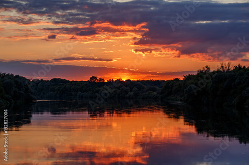 Sunset over the river don. Crimson clouds reflected in the water © VASILEVS