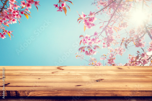 Top of wood empty ready for your product and food display or montage with pink cherry blossom flower  sakura  on sky background in spring season. vintage color tone.