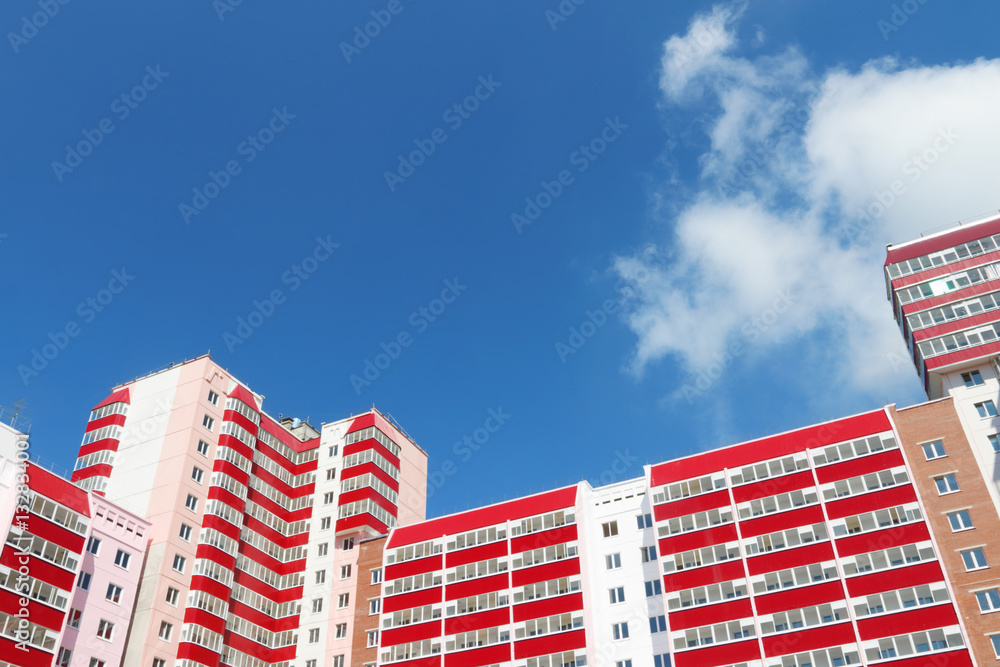 Part of residential building with balconies at sunny day, clouds
