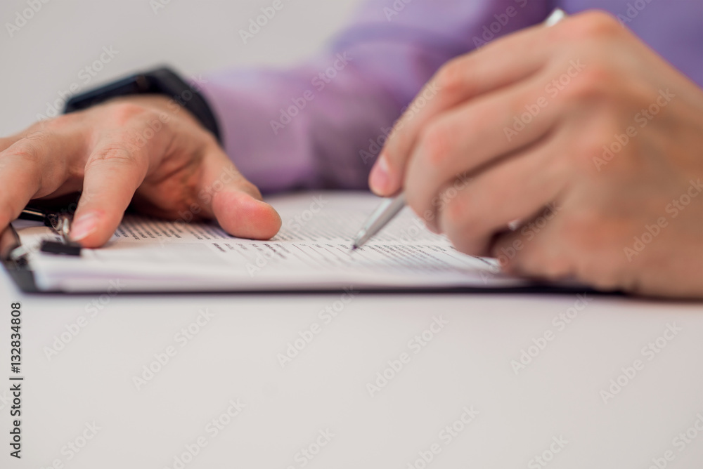 Close up Human Hand Signing on Formal Paper at the Table. Close up Human Hand Signing on Formal Paper at the Table.