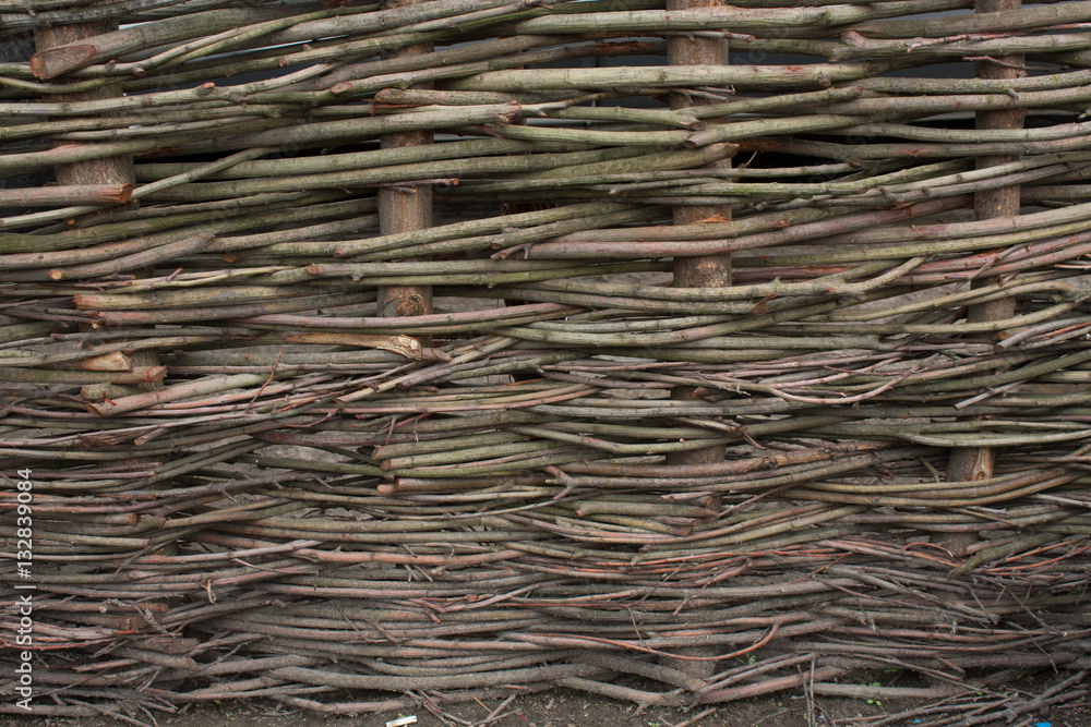 Wooden rustic fence made with chopped branches intertwined togather Wooden rustic fence made with chopped branches intertwined togather