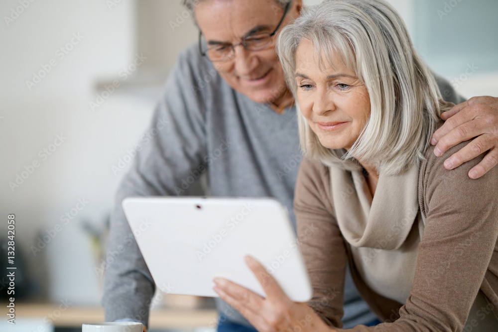 Senior couple at home using digital tablet Senior couple at home using digital tablet