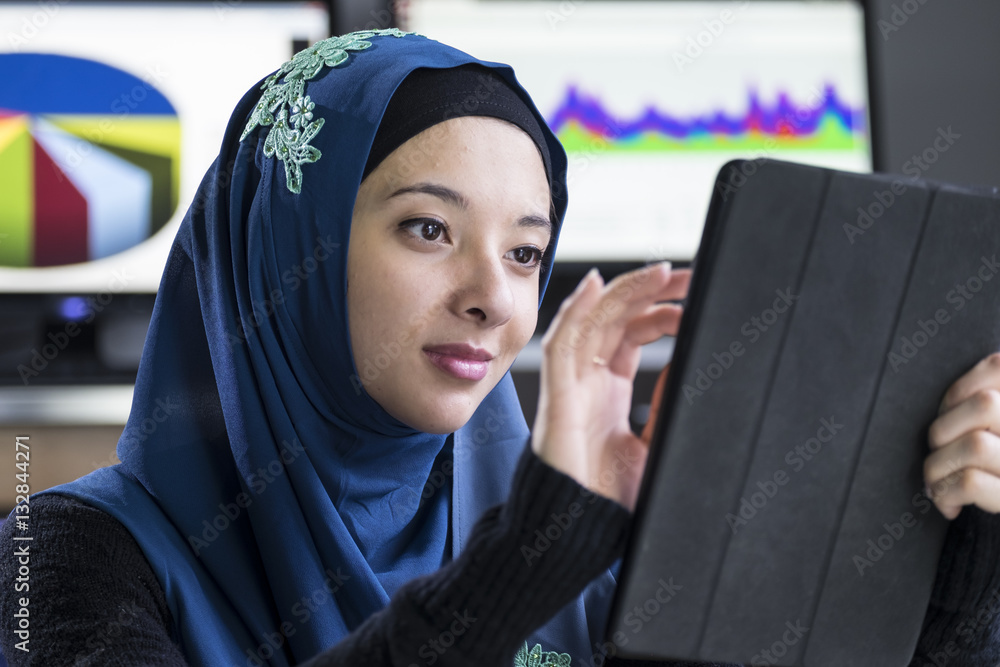 Young woman wearing a hijab using an ipad/tablet Young woman wearing a hijab using an ipad/tablet