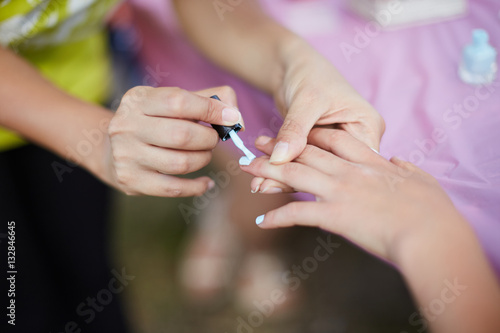 young girl on a manicure. paint nails