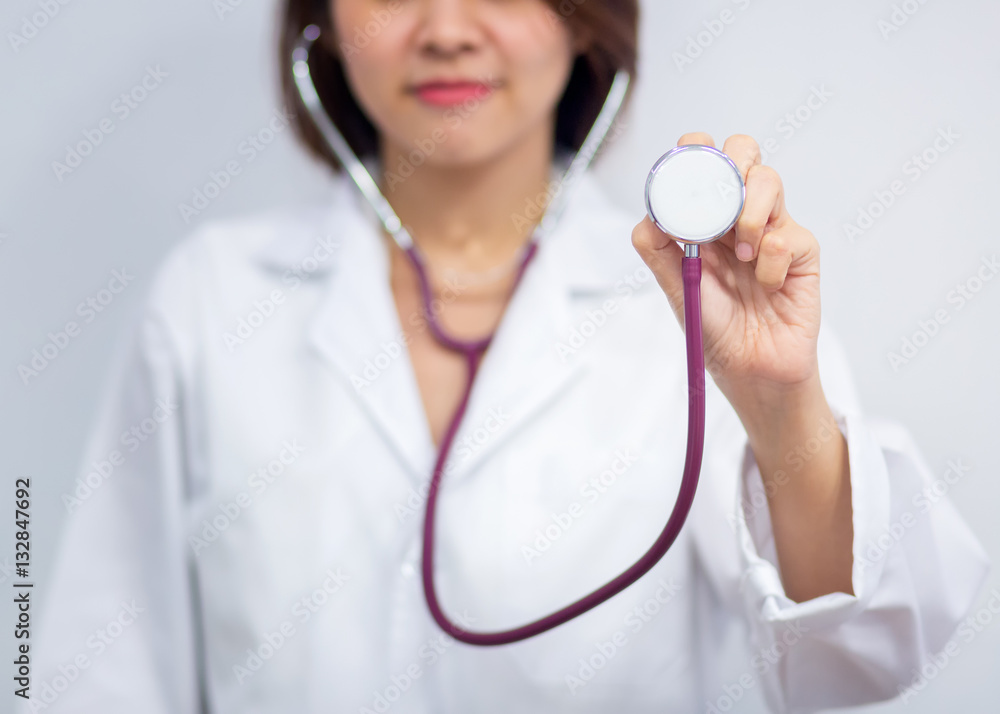 Medical doctor woman on a white background holding a stethoscope focus on the stethoscope Medical doctor woman on a white background holding a stethoscope focus on the stethoscope