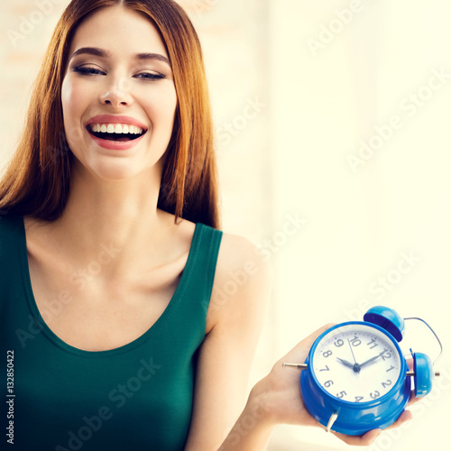 Woman with blue alarmclock, at home photo