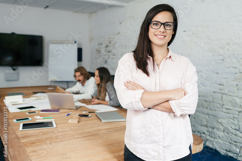 Slika na platnu Young businesswoman looking the camera and smiling during a meeting work in offi