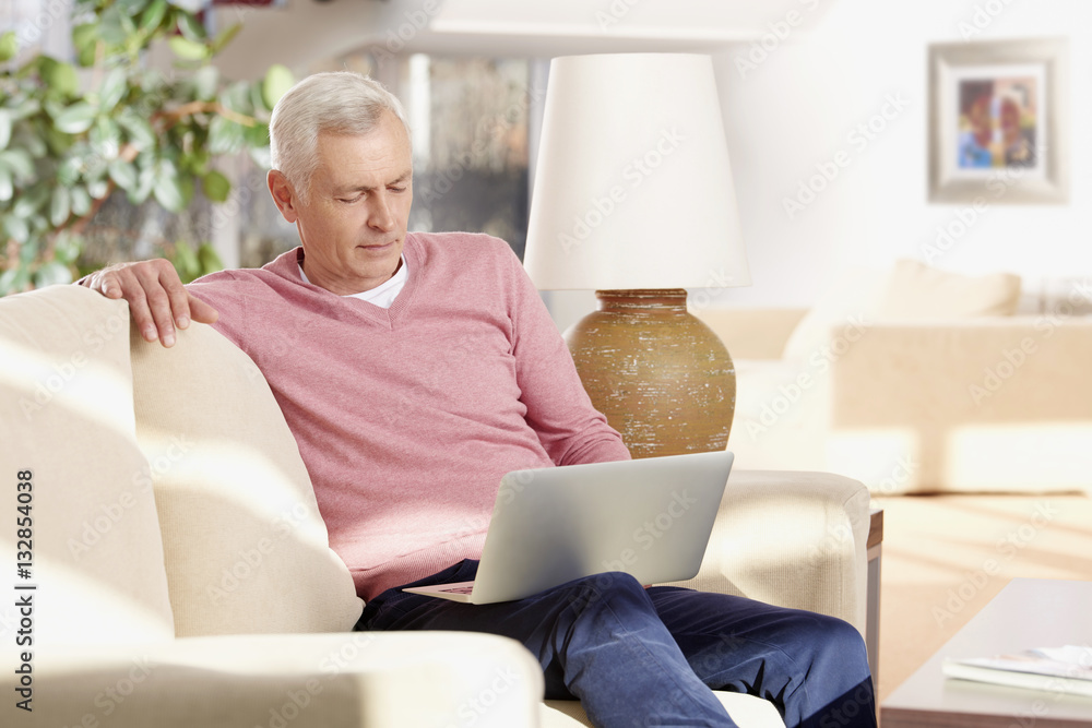 Active senior man banking online. Shot of a senior man using laptop while manage his finances online from home. Active senior man banking online. Shot of a senior man using laptop while manage his finances online from home.