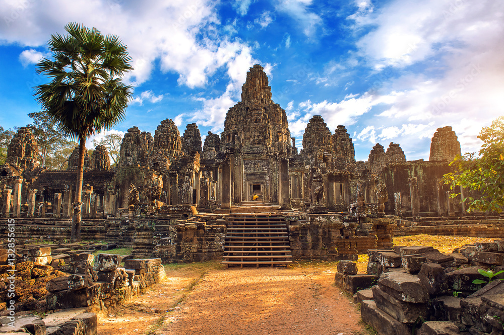 Naklejka premium Starożytne kamienne twarze o zachodzie słońca świątyni Bayon, Angkor Wat, Siam