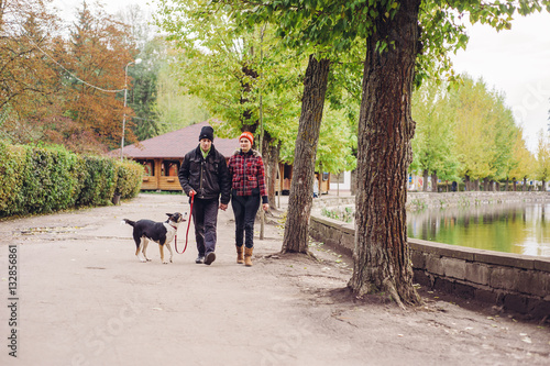 couple walking a dog park © hetmanstock2