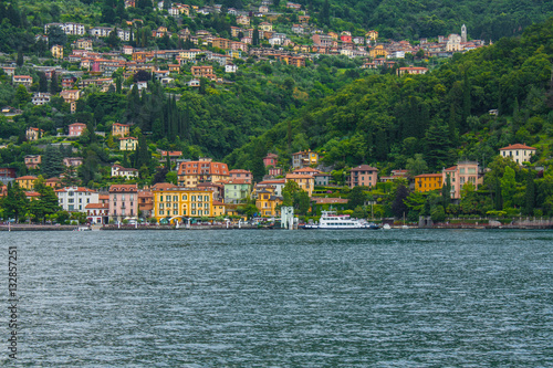 View on coast line of Lake Como, Italy, Lombardy region. Italian landscape, with Mountain and city with many colorful buildings on the shore © saint_antonio