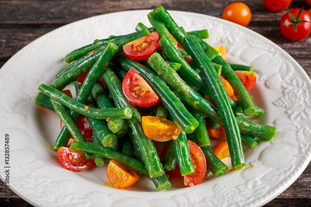 Green beans salad with Red, Yellow Tomatoes on white plate