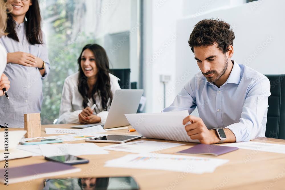Young businesswoman and businessman during a meeting in office to launch start-up. They speak, show graphs and charts Young businesswoman and businessman during a meeting in office to launch start-up. They speak, show graphs and charts