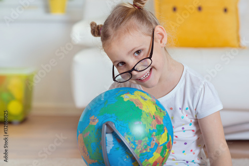 Pretty child girl at home dreaming of travel and tourism, explor photo