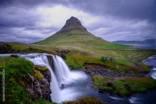 Kirkjufell mountain under a dark cloudy sky with waterfall in foreground