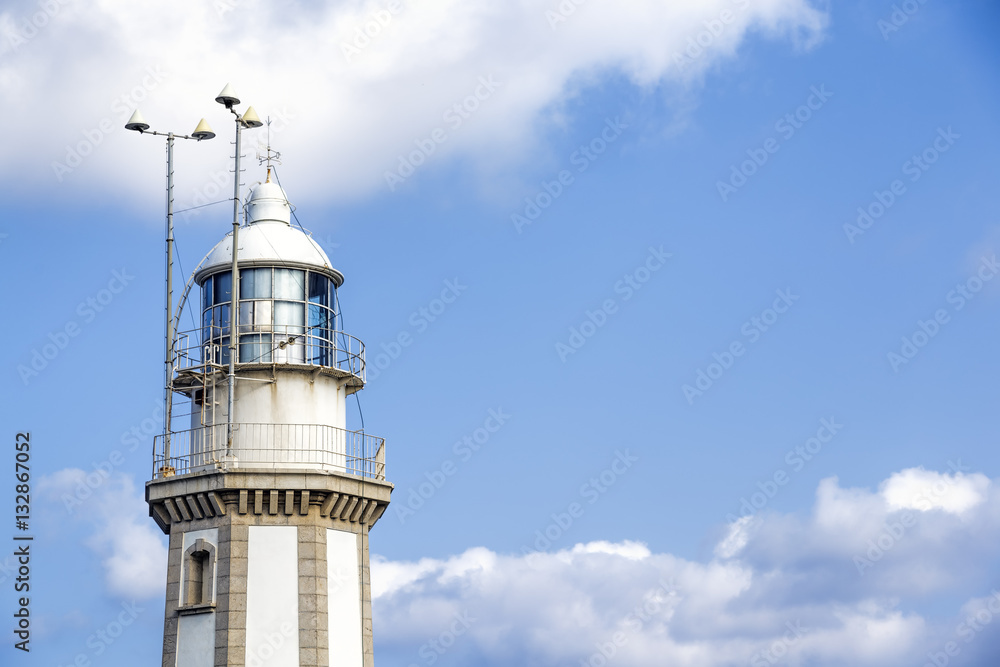 Lighthouse against blue sky and clouds