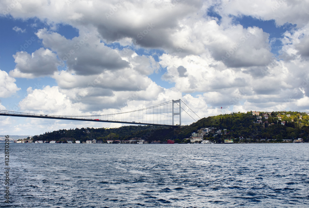 FSM (Fatih Sultan Mehmet) bridge under dramatic clouds in autumn. Bosphorus strait and Asian side of Istanbul are in the view. It is internationally-significant waterway located in northwestern Turkey